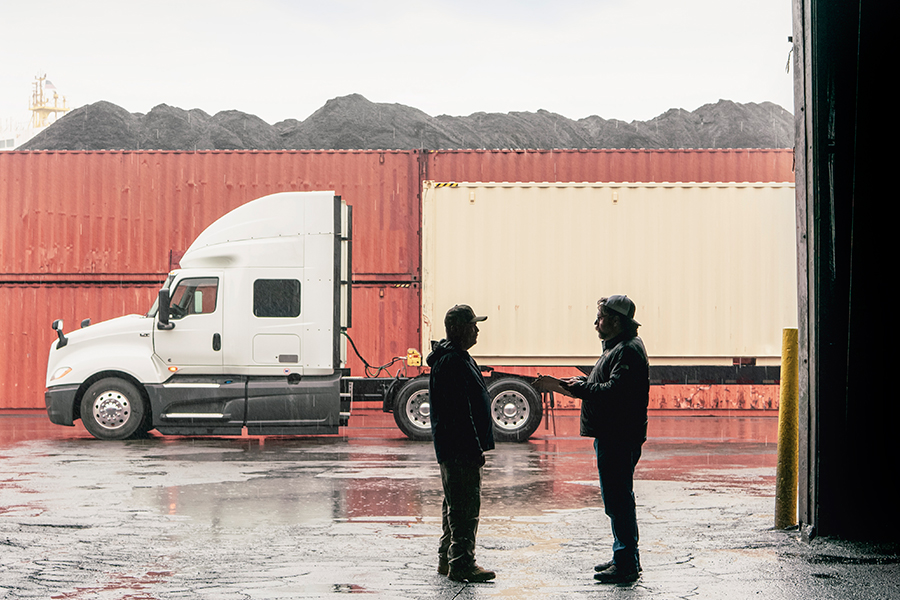 financing_international_proven_trucks_white_truck_parked_with_two_males_talking_in_garage (1)